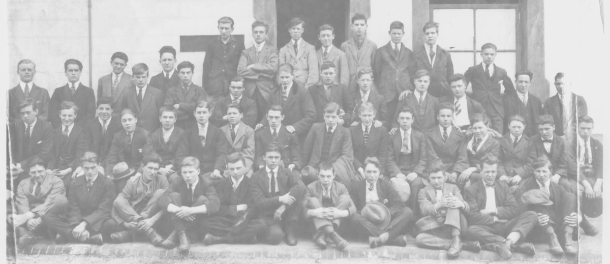 Image: Fifty young men in suits pose for a group photo outside a building