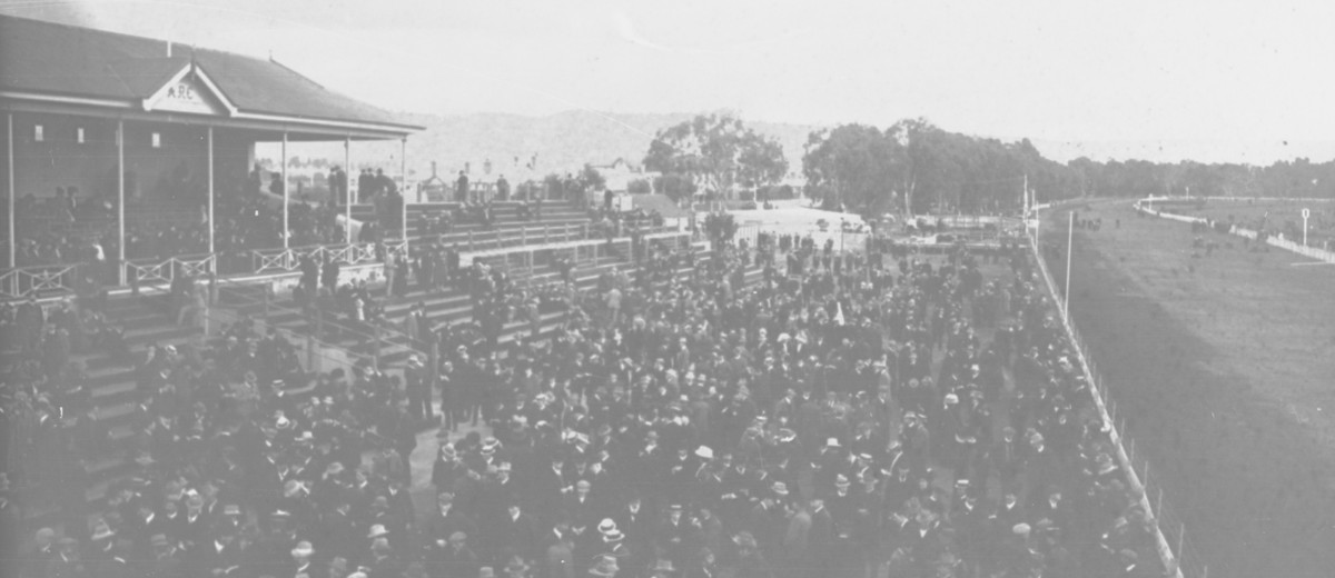 Image: large crowd of people at horse race track