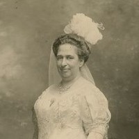 Image: black and white photo of woman standing in white dress and veil