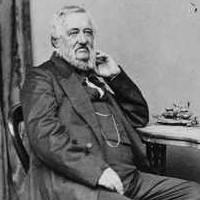 Image: Black and white photograph of seated man in three quarter profile