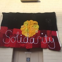 Image: knitted Aboriginal flag