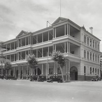 Image: three storied building with large, front facing balcony