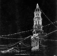 Image: A building with a tall tower and rotunda is illuminated by lights at night