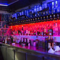 Image: bench top covered in large number of bottles of alcohol